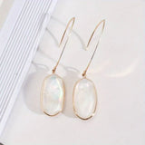 Dangling earrings with a white stone