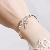 Adjustable bracelet with three leaf-shaped silver pendants