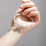 Adjustable bracelet with three leaf-shaped silver pendants
