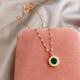 Golden necklace with an emerald