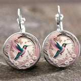 A hummingbird-shaped pendant necklace with a glass dome