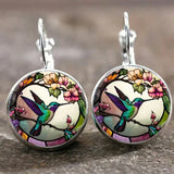 A hummingbird-shaped pendant necklace with a glass dome