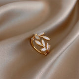 Adjustable ring with white opal leaf in a gold frame