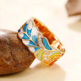Vintage golden ring with a colorful enamel leaf