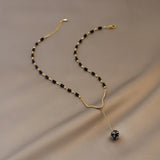 Classic necklace with black beads and a teardrop pendant