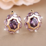 Round gold earrings with purple zircon